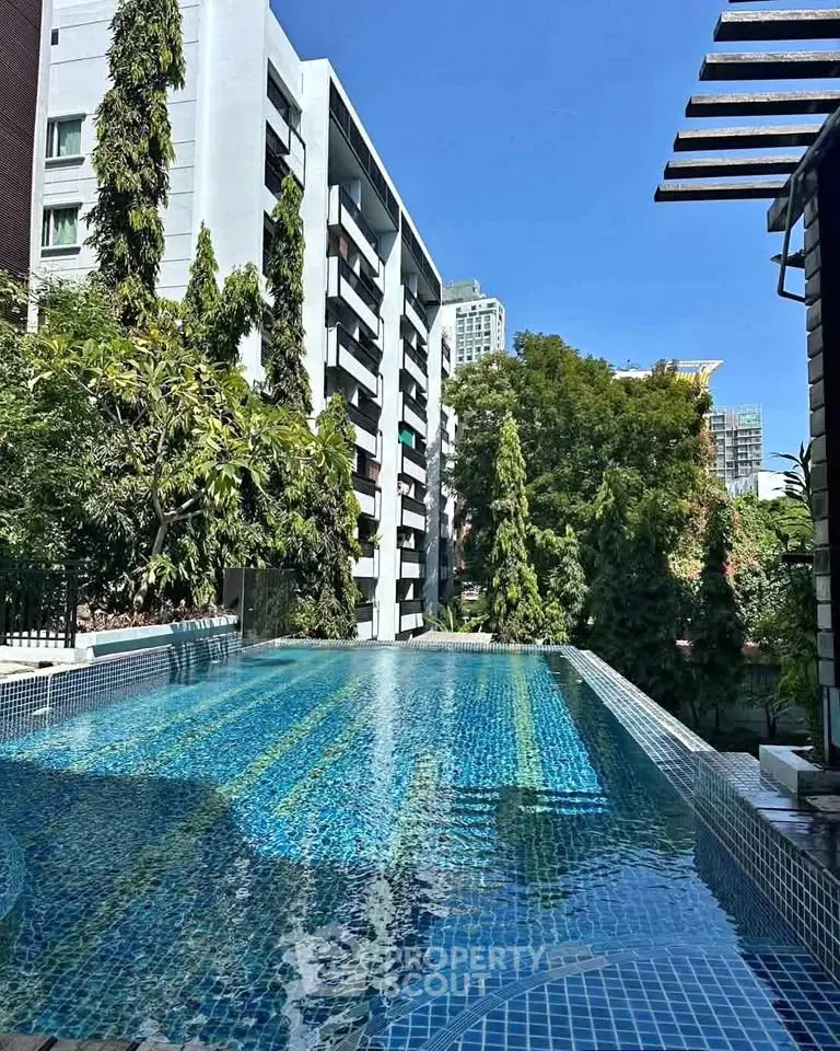 Luxurious rooftop pool with stunning city views in modern residential building.