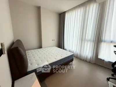 Spacious bedroom with large windows and natural light in modern apartment