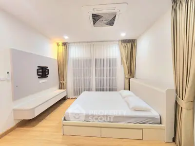 Spacious modern bedroom with elegant decor and ample natural light