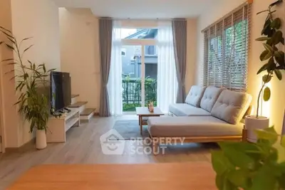 Modern living room with large windows and stylish furniture, offering a cozy and inviting atmosphere.