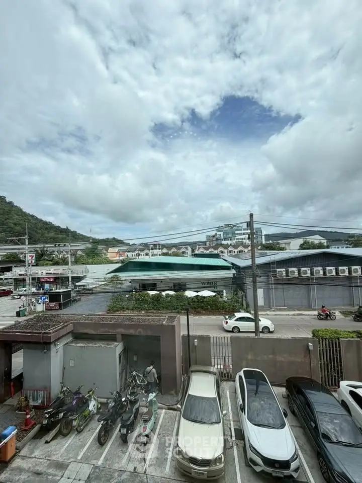 Scenic view from a parking lot with mountains and buildings in the background.