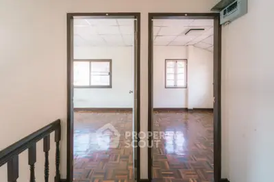 Spacious interior with wooden flooring and large windows for natural light