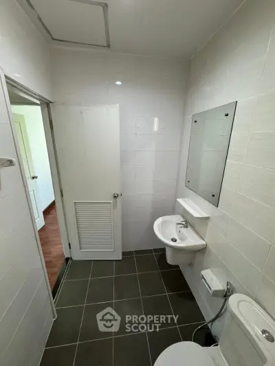 Modern bathroom with sleek white tiles and minimalist fixtures, perfect for a contemporary home.