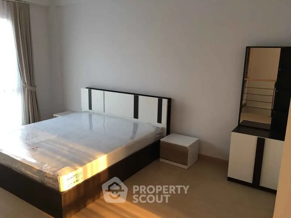 Modern minimalist bedroom with natural light and sleek furniture design.
