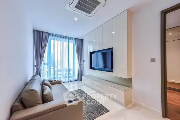 Modern living room with sleek furniture and large TV, featuring floor-to-ceiling windows and elegant curtains.