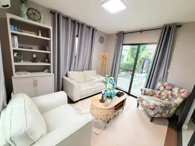 Charming living room with cozy seating and garden view, perfect for relaxation.