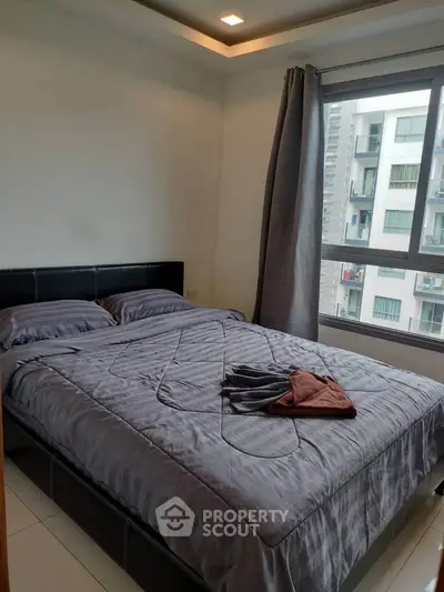 Cozy bedroom with large window and modern decor in urban apartment