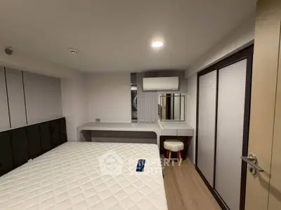Modern bedroom with sleek design, featuring a comfortable bed, built-in wardrobe, and air conditioning.