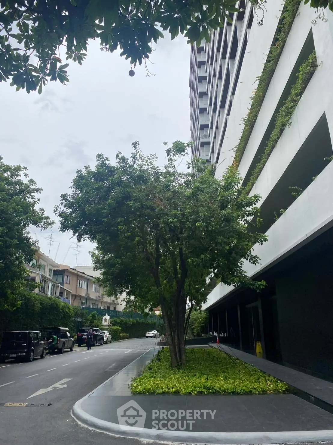 Modern building exterior with lush greenery and street view
