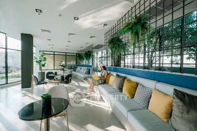 Modern living room with stylish decor and large windows offering natural light and greenery.