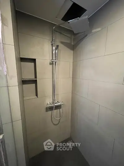 Modern bathroom shower with sleek tile design and rainfall showerhead, perfect for a contemporary home.