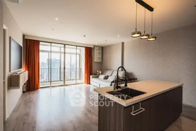 Spacious modern living room with open kitchen and city view balcony.