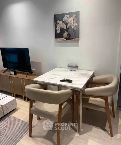 Modern living room with stylish furniture and elegant decor, featuring a marble dining table and contemporary TV stand.