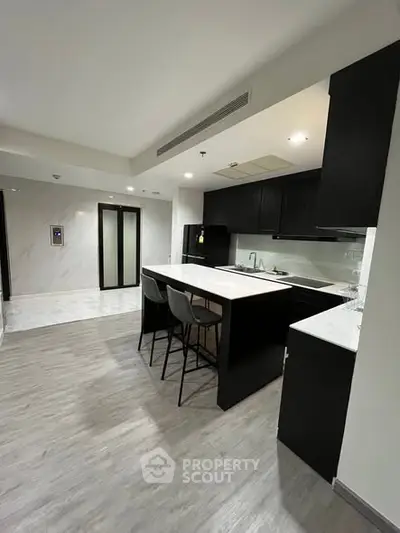 Modern kitchen with sleek black cabinets and island seating
