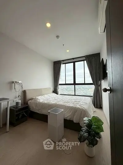 Modern bedroom with large window offering stunning city view, featuring minimalist decor and cozy ambiance.