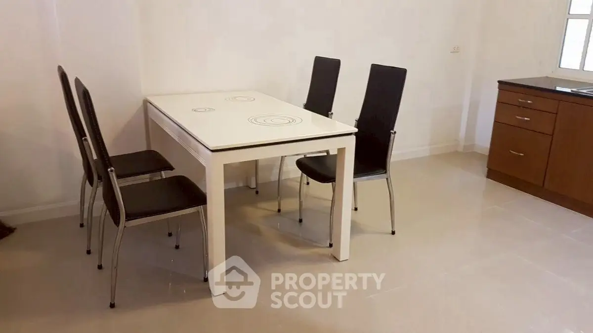 Modern dining area with sleek table and chairs in a minimalist kitchen setting.