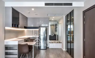 Modern open-layout kitchen with sleek cabinetry and stainless steel appliances in a stylish apartment.