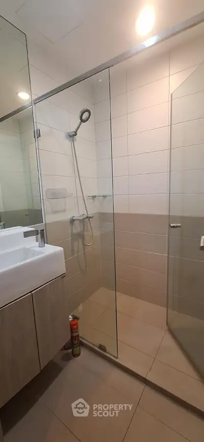 Modern bathroom with glass shower enclosure and sleek vanity