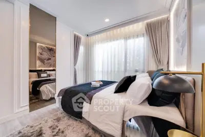 Luxurious bedroom with plush bedding, elegant drapery, and a sophisticated color palette, featuring a large bed with a unique headboard and a soft, textured rug.