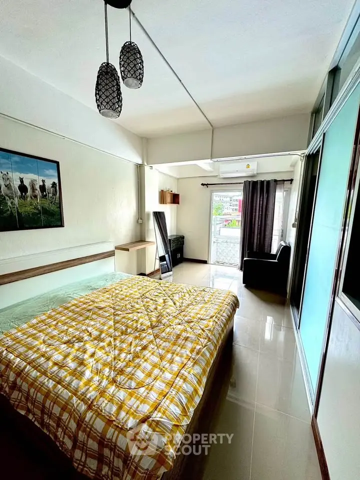 Spacious bedroom with modern decor and large window for natural light