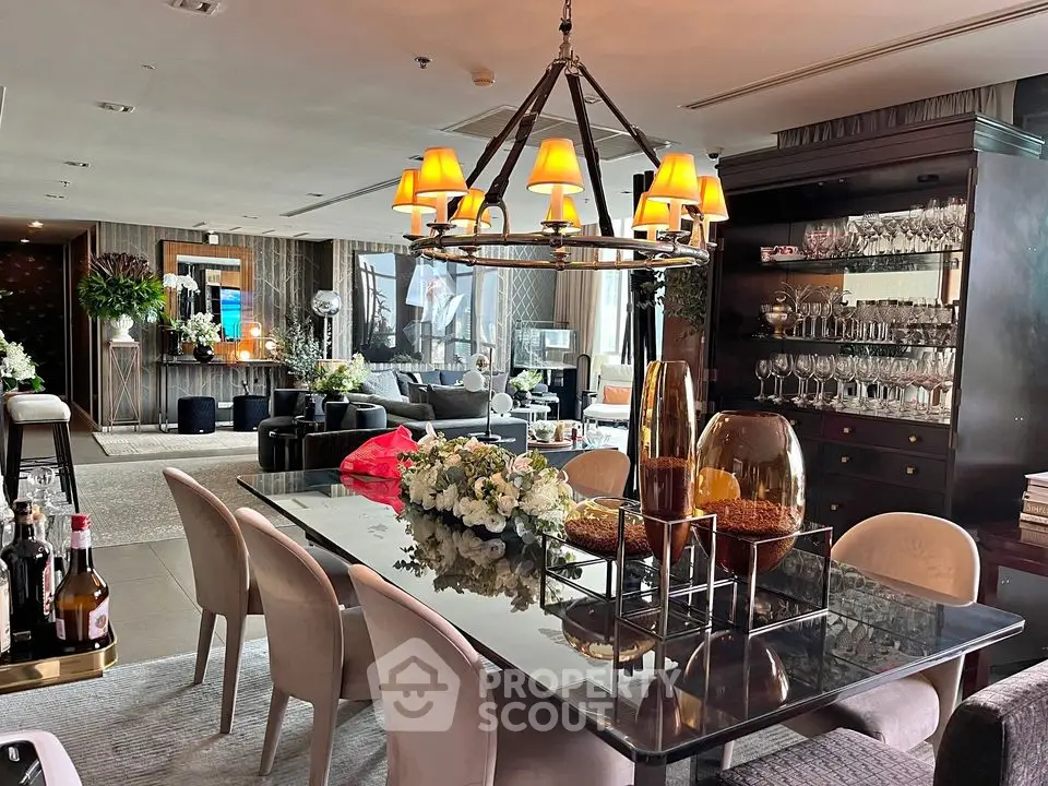 Luxurious dining area with elegant chandelier and stylish decor in modern open-plan living space.