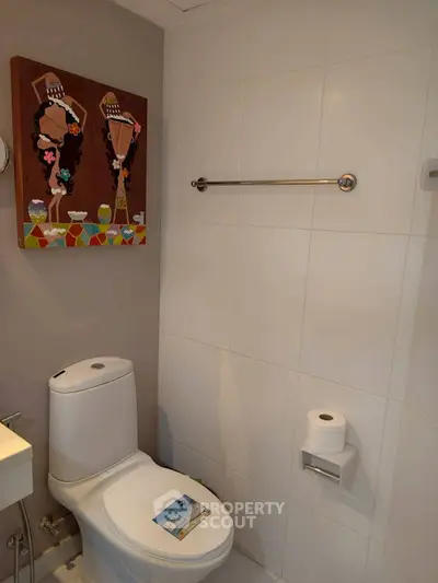 Modern bathroom with white tiles and contemporary art piece