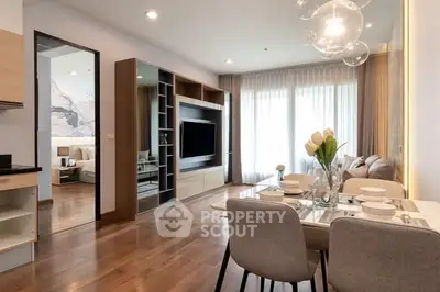 Modern living room with dining area, featuring elegant decor and natural light.