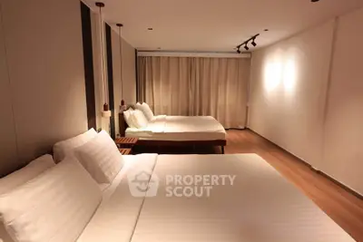 Spacious modern bedroom with two large beds and elegant lighting