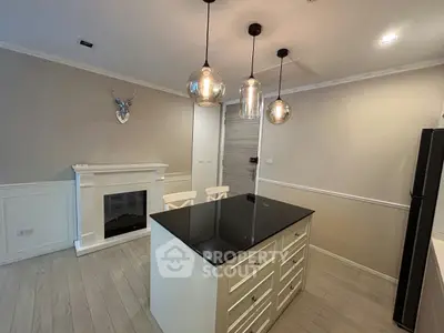 Chic modern kitchen with island and elegant lighting, featuring a cozy fireplace and sleek cabinetry.