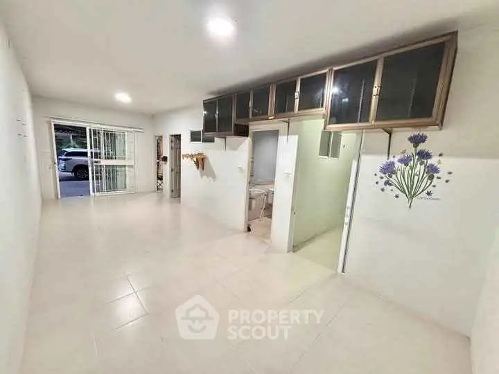 Spacious open-plan living area with modern cabinetry and floral wall decor