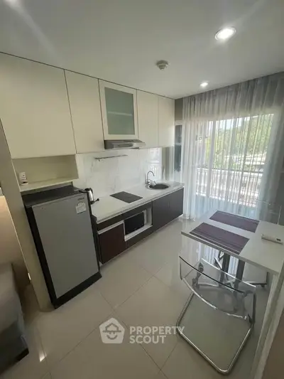 Modern kitchen with sleek design, featuring built-in appliances and a cozy dining area.