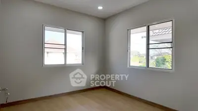 Bright empty room with large windows and wooden flooring in modern home