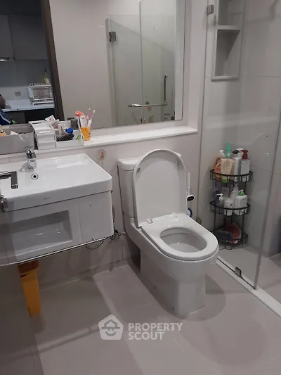 Modern bathroom with sleek fixtures and glass shower enclosure.