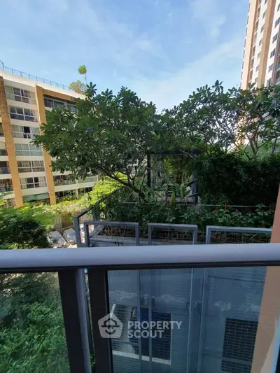 Charming garden view from a modern balcony in a residential complex.