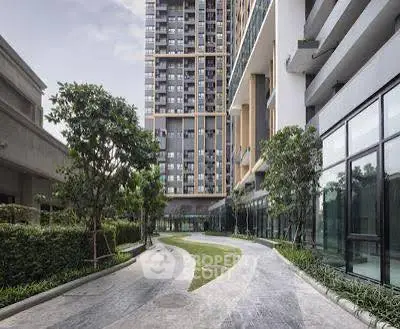 Modern high-rise building with landscaped pathway and greenery