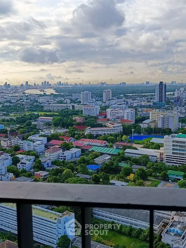 Stunning cityscape view from a high-rise balcony showcasing urban skyline and lush greenery.
