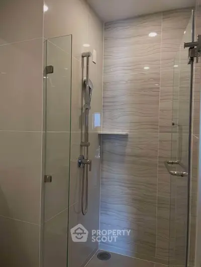 Modern bathroom with sleek glass shower enclosure and elegant tile design.