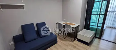 Modern living room with blue sofa and dining area in a bright apartment.