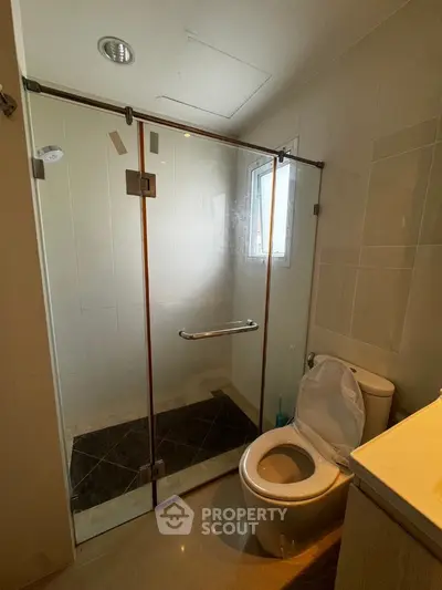 Modern bathroom with glass shower enclosure and sleek fixtures