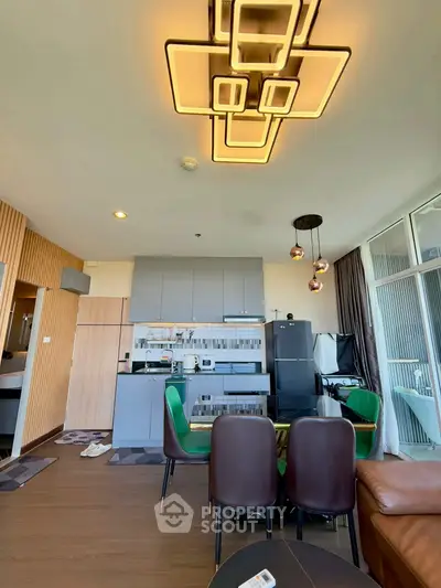 Modern open-plan living room with stylish lighting and contemporary kitchen design.