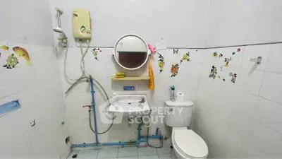 Cozy bathroom with shower, sink, and toilet, featuring playful wall decals for a charming touch.