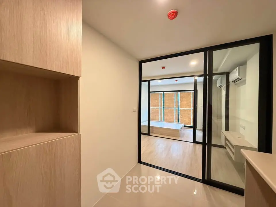 Modern apartment interior with sliding glass doors and wooden cabinetry
