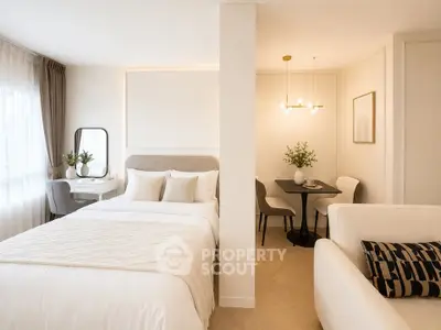 Elegant bedroom with cozy dining area and modern decor in a stylish apartment.