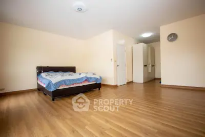 Spacious bedroom with wooden flooring and modern decor