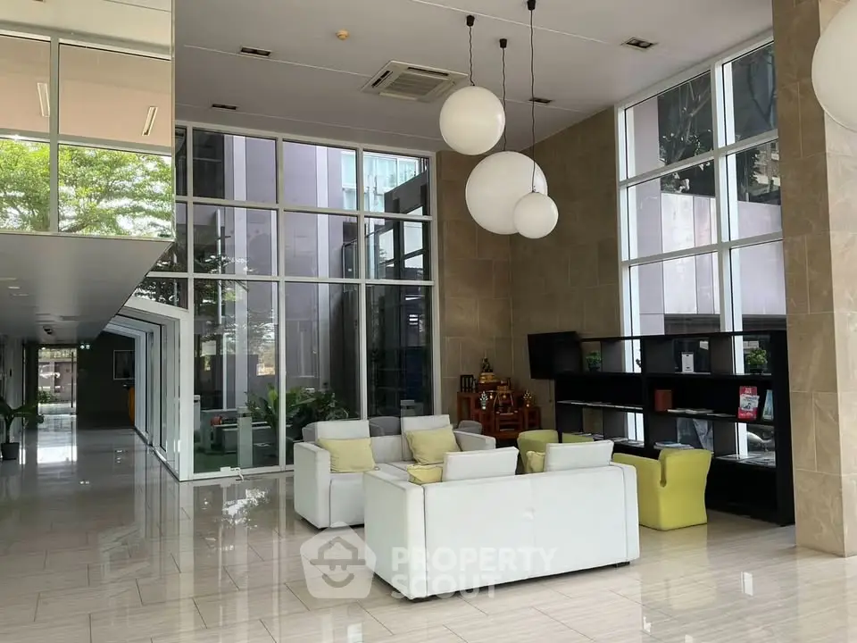 Luxurious modern lobby with high ceilings and elegant seating area in a contemporary building.
