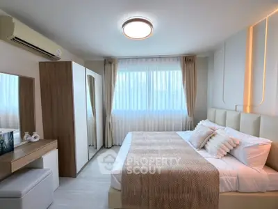 Elegant bedroom with modern decor, large window, and stylish furniture
