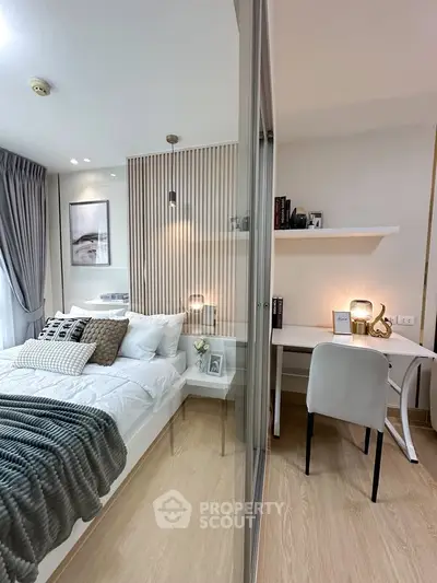 Modern bedroom with cozy study area, featuring elegant decor and natural light.