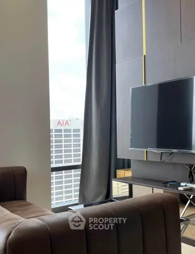 Modern living room with large window and sleek TV setup in urban apartment.