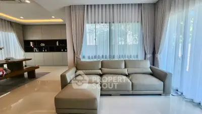 Luxurious living room with elegant beige sofa and floor-to-ceiling windows.