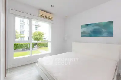 Bright and airy bedroom with large window and modern decor in a contemporary apartment.